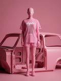 Pink streetwear set with Persian script tee and shorts, styled with car body in monochrome pink studio