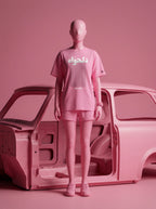 Pink streetwear set with Persian script tee and shorts, styled with car body in monochrome pink studio