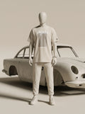 White streetwear outfit with Persian-inspired design, paired with classic car backdrop
