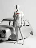White t-shirt with Persian text and 'Javeadon' branding, styled with shorts and sneakers beside a classic car.