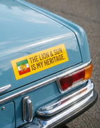 Yellow car decal with Lion & Sun emblem and text 'The Lion & Sun Is My Heritage' on vintage blue car trunk.
