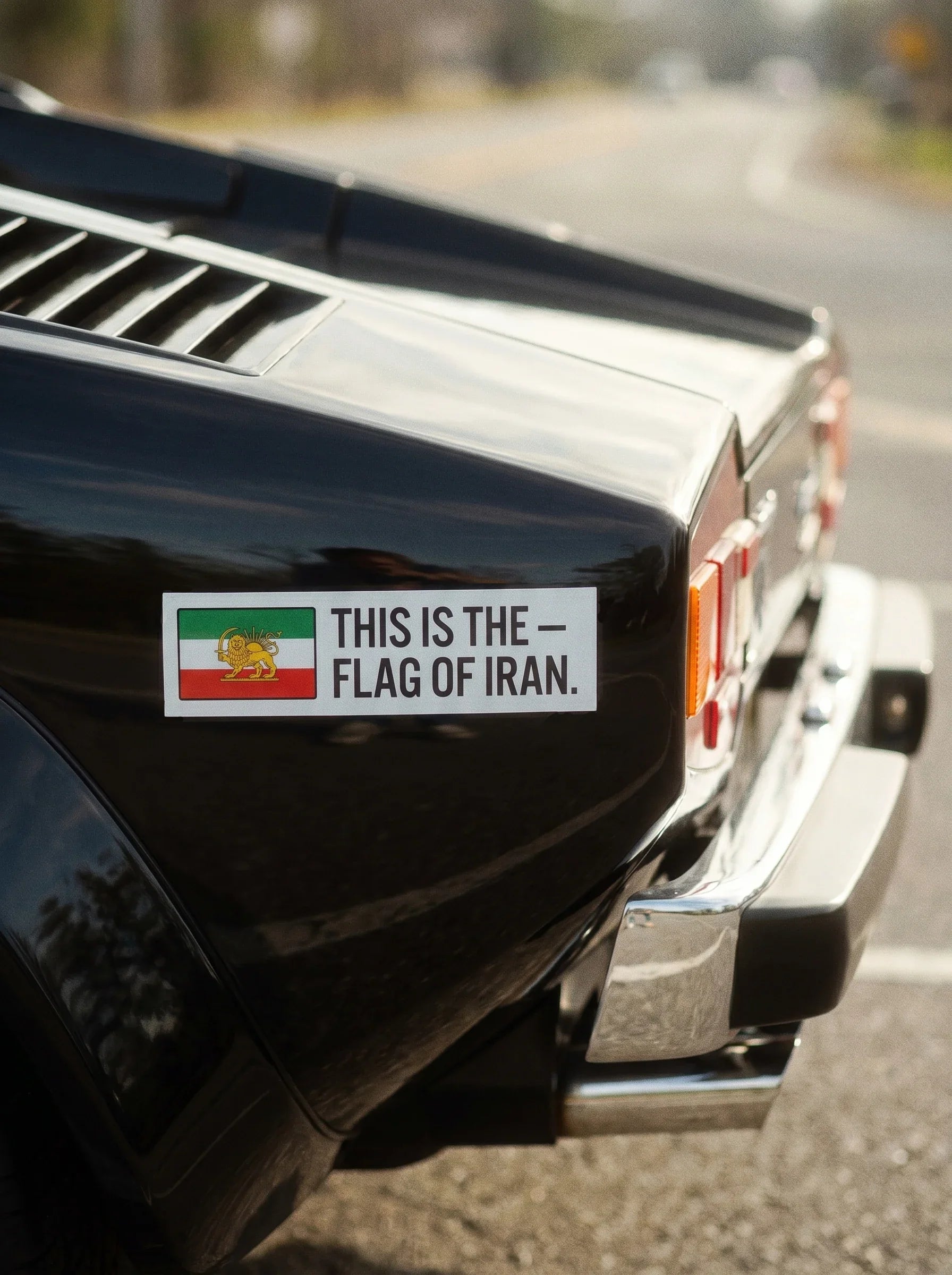 Car rear with Iran flag sticker featuring Lion and Sun, symbolizing Persian heritage and identity.