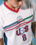 White mesh jersey with red collar, USA flag stripes, 'Iranians for US' text, soccer ball, and number 8