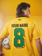 Yellow soccer jersey with green number 8, custom name, and Persian heritage patch, held with Adidas ball